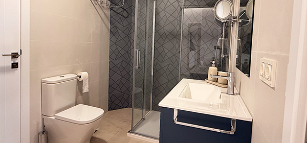 Baño moderno con ducha y toallas blancas